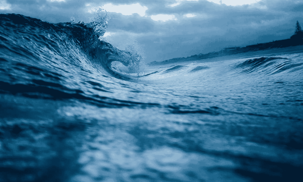 Powerful ocean waves crashing under a cloudy sky, representing strength, resilience, and new beginnings.